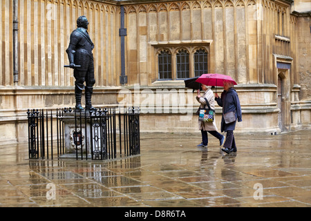 Giro turistico sotto la pioggia presso il Conte di Pembroke, statua di William Herbert fuori dalla Bodleian Library a Oxford, Oxfordshire Regno Unito in una giornata piovosa bagnata a maggio Foto Stock