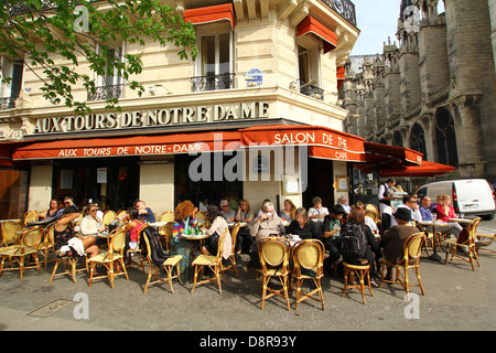 Cafe 'Aux Tours de Notre Dame' vicino alla cattedrale di Notre Dame, persone in chat con un drink godendo di primo sole di primavera a Parigi, Francia Foto Stock