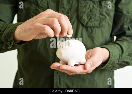 Salvadanaio di banca di monete in mani a tazza dell'uomo. Foto Stock