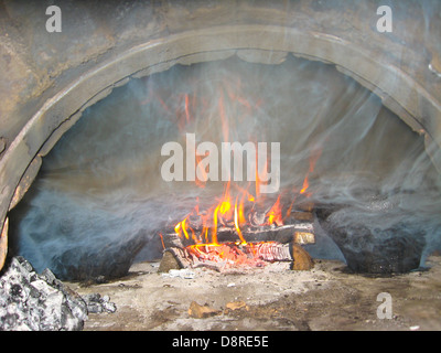 La legna brighly bruciare nel forno Foto Stock