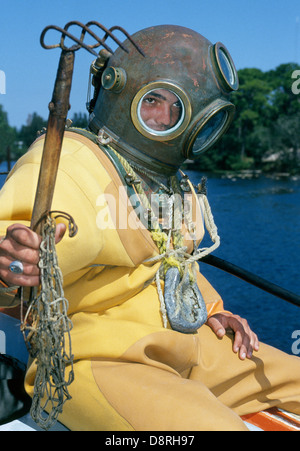 Un giovane subacqueo in spugna in un tradizionale hard-hat campana muta entra nel Golfo del Messico con la sua spugnatura rastrello vicino a Tarpon Springs, in Florida, Stati Uniti d'America. Foto Stock
