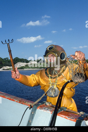 Un giovane subacqueo in spugna in un tradizionale hard-hat campana muta mostra la sua spoglia e borsa a rete con una spugna raccolte nei pressi di Tarpon Springs, in Florida, Stati Uniti d'America. Foto Stock