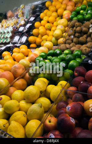 I Limoni e limette, arance e pesche sul display nel negozio di alimentari di produrre la sezione. Foto Stock