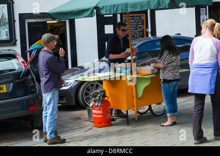 Un uomo con un macaw sulla sua spalla sul mercato a Keswick Foto Stock