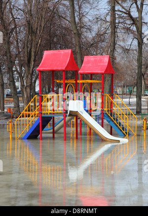 Le acque di esondazione svuotare il parco giochi per i bambini Foto Stock