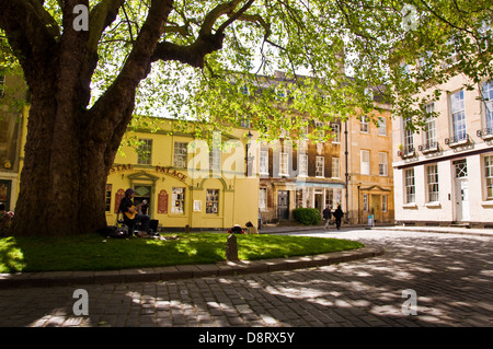 Un suonatore ambulante suona la chitarra su Abbey verde nel centro di Bath Foto Stock