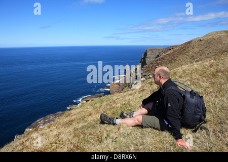 Uomo che guarda la vista con il vecchio uomo di Stoer in background in Sutherland Scozia Scotland Foto Stock