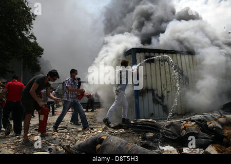 Istanbul, Turchia. Il 4 giugno 2013. Protestor provare a mettere giù un incendio in un contenitore utilizzato per la costruzione dei lavoratori nel Giugno 4, 2013 ad Istanbul in Turchia.Le proteste ha cominciato inizialmente per il destino di Taksim Gezi Park, uno degli ultimi significativi spazi di verde nel centro della città Credito: Yiannis Kourtoglou/Alamy Live News Foto Stock