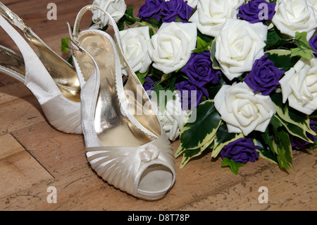 Scarpe di nozze con bouquet di fiori sul pavimento in legno Foto Stock