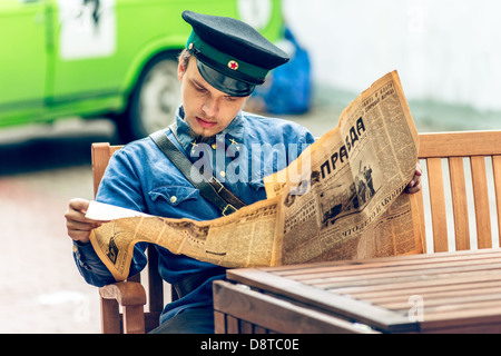 Mosca, Russia - festival retrò 'giorni di storia' in Hermitage Garden. Uomo in uniforme di lettura giornale sovietico. Maggio 26, 2013 Foto Stock