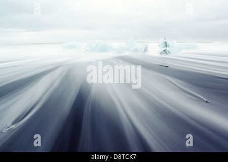 Iceberg su nero spiaggia vulcanica, Islanda Foto Stock