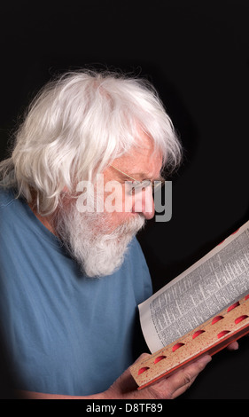 Uomo anziano la lettura di un libro, scienziato e Maestro con la barba e occhiali di protezione Foto Stock