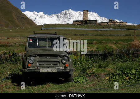 Antica russa UAZ jeep, torri di pietra e case tradizionali nel villaggio di Ushguli Svaneti, Georgia, nel Caucaso mountain Foto Stock