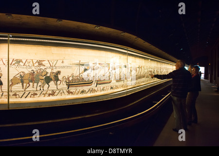 Un paio di turisti ammirando l'arazzo di Bayeux o La Tapisserie de la Reine Mathilde nella visualizzazione corrente caso Foto Stock