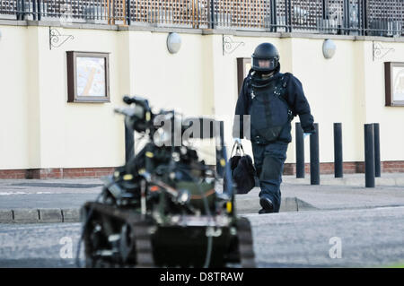 Carrickfergus, Irlanda del Nord. Il 4 giugno, 2013. Un esercito di ATO da "Bomb Squad' vestito in un a prova di bomba suit cammina dietro un 'carriola' senza equipaggio veicolo robotico. Credito: Stephen Barnes/Alamy Live News Foto Stock