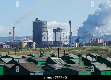 Vista su Fishermens capanne con Redcar acciaierie altoforno in background. A sud di gare, Redcar, England, Regno Unito Foto Stock