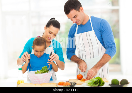 Insegnamento madre figlia piccola insalata di miscelazione quando la cucina di famiglia in cucina Foto Stock