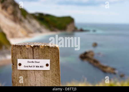 Riferimento griglia sul palo da recinzione dando posizione della mappa per gli escursionisti a porta di Durdle nel Dorset. Al di fuori della messa a fuoco lo sfondo. Foto Stock