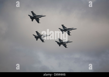 Quattro F/A-18 Hornet jet fighter aircraft del Royal Australian Airforce volare in formazione contro il cielo grigio Foto Stock