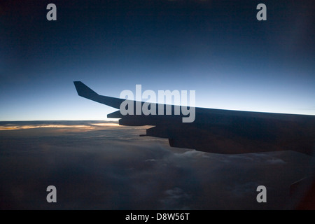 Anta di porta di un Boeing 747-400 della Cathay Pacific aereo di linea, visto dal finestrino passeggero stagliano candelette di primi albori sky Foto Stock