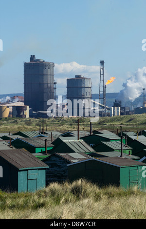 Vista su Fishermens capanne con Redcar acciaierie altoforno in background. A sud di gare, Redcar, England, Regno Unito Foto Stock