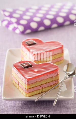 Mousse di lamponi a forma di cuore le torte a base di pan di spagna Foto Stock