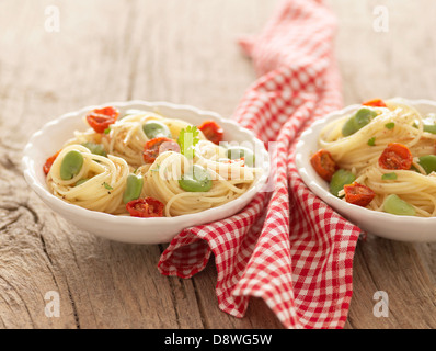 Spaghetti con fave e essiccate al sole di pomodori ciliegini Foto Stock