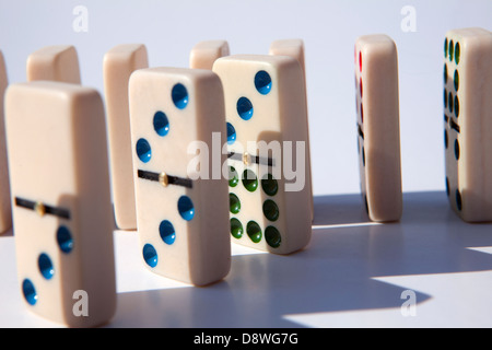 Close up di domino piastrelle in fila su sfondo bianco, studio shot Foto Stock