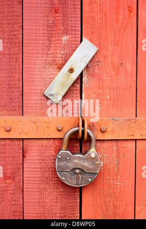 Il lucchetto bloccando la porta di legno Foto Stock