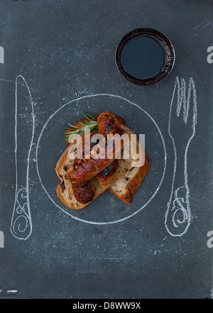 Pane con salsicce alla griglia e un bicchiere di vino; la piastra,coltello e forchetta disegnato sulla tavola Foto Stock