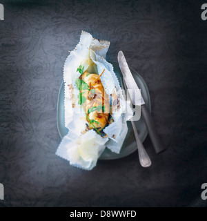 Pollo al limone cotto in carta oleata Foto Stock