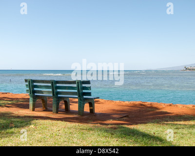 Lonely una panchina nel parco affacciato sull'oceano sulla Spiaggia Foto Stock