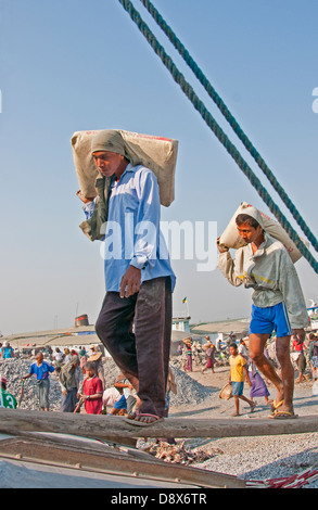 Operai di scarico sulla chiatta Ayeyarwaddy fiume vicino a Mandalay. Foto Stock