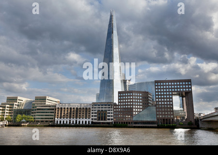 Vista della riva sud del fiume Tamigi vicino al London Bridge con la Shard, Hays Galleria, London Bridge Hospital. Cielo tempestoso. Foto Stock