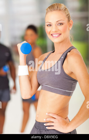 Attraente giovane donna di montare il sollevamento di pesi Foto Stock