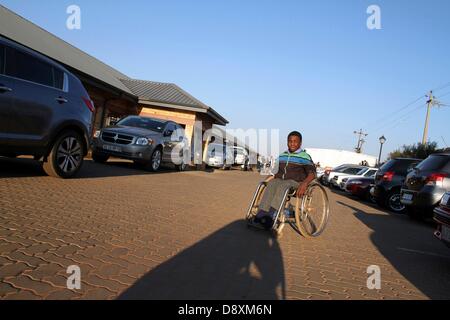 JOHANNESBURG, SUD AFRICA: Thabang Diholo il 5 giugno, 2013, a Johannesburg, in Sud Africa. Data di nascita paraplegico, Diholo è legato in sedia a rotelle ma preferisce spostarsi usando un vecchio skateboard. Il 16-anno-vecchio non richiede alcun trattamento speciale dai suoi coetanei ed è determinata a studiare ulteriormente, verso una vita migliore. (Foto di Gallo Immagini / Sowetan / Bafana Mahlangu) Foto Stock