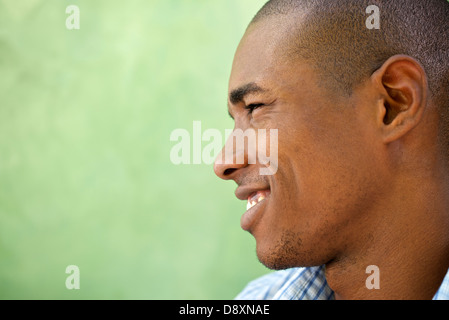 Ritratto di felice giovane americano africano l uomo che guarda lontano e sorridente. Testa e spalle, spazio di copia Foto Stock