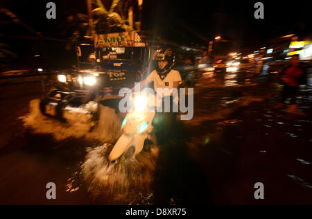 Davao, Filippine. Il 6 giugno 2013. Automobilista passa su acqua di inondazione causata da una forte pioggia a Davao City, nel sud delle Filippine, 06 giugno 2013.Il filippino atmosferica, geofisici e astronomici di amministrazione dei servizi (PAG-ASA) ha detto che una zona di convergenza intertropicale ITCZ () pregiudicare il sud della maggior parte delle Filippine che innesca hi livello di acqua di inondazione in città. Credito: Eli Ritchie Tongo/Alamy Live News Foto Stock