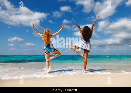 Due giovani donne con le mani alzate Foto Stock