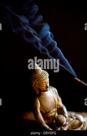 Budda statuetta con bastoncini di incenso Foto Stock