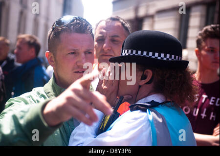 Londra, Regno Unito. Il 6 giugno 2013. Una donna di polizia sussurra all'orecchio della Difesa inglese League (EDL) leader Tommy Robinson di fronte alla Old Bailey come sostenitori di estrema destra della Difesa inglese League (EDL) protestare il giorno della condanna di sei uomini supplicato colpevole per la pianificazione di un attacco terroristico su un EDL rally a Dewsbury. Credito: Piero Cruciatti/Alamy Live News Foto Stock