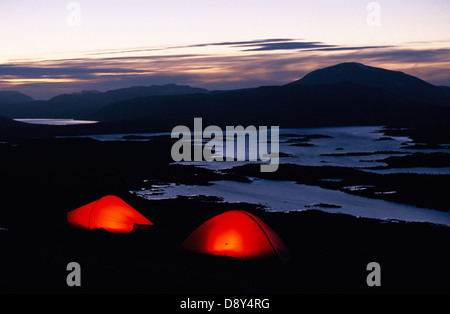 Due tende rosse in montagna nel crepuscolo. Foto Stock