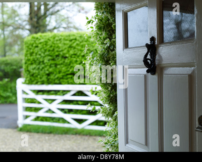 Una foto scattata dalla porta di una casa che guarda fuori in un giardino. Foto Stock