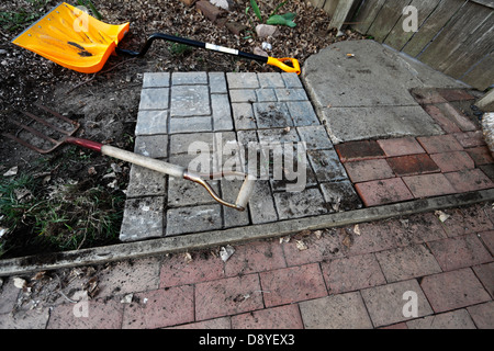 Il patio in costruzione, mostrando square lastricatore i blocchi accanto ai vecchi mattoni. Foto Stock