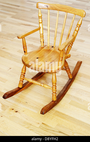 Baby intagliata in legno sedia a dondolo sul pavimento in parquet Foto Stock