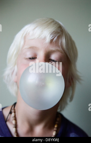 Un ragazzo soffia un chewing-gum bolla. Foto Stock