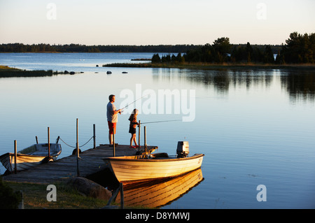 Padre e figlia la pesca dal molo, Svezia. Foto Stock