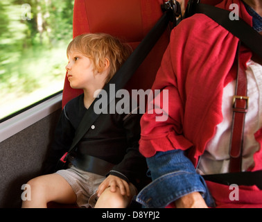 Ragazzo che guarda al di fuori della finestra di bus Foto Stock
