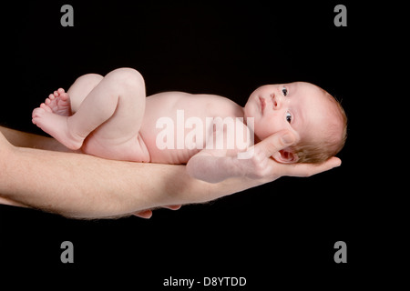 Padre tenendo i suoi quindici giorni baby sul suo braccio Foto Stock