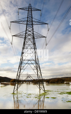 Pylons elettrici in piedi allagato campagna nella valle del fiume exe, a Stoke Canon, vicino Exeter, Devon, Gran Bretagna. Foto Stock